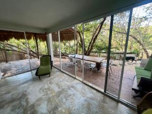a room with glass windows and a table and chairs at Casa Pauline Beach house habitaciones con acceso directo a playa y alberca in Arroyo Cruz