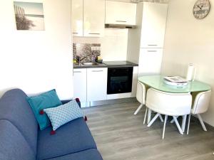 Una sala de estar con un sofá azul y una mesa. en Maisonnette à 30 mètres de la plage, en Saint-Denis-dʼOléron 10 fotos más