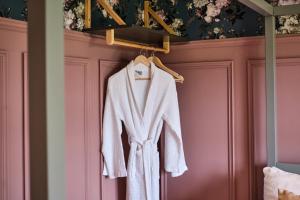 a white robe hanging on a rack in a room at Carnbore House BnB in Bushmills