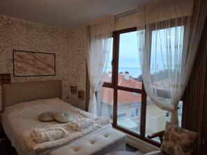 a bedroom with a bed and a large window at Magi Sunrise in Balchik