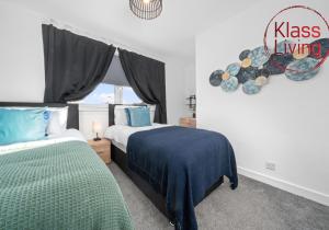 a bedroom with two beds and a sign that reads kiss living at Orbiston House by Klass Living Bellshill in Bellshill