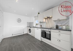 a kitchen with white cabinets and a stove at Orbiston House by Klass Living Bellshill in Bellshill