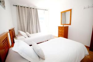 two white beds in a bedroom with a window at Las Cascadas Puerto de Mogán II in Puerto de Mogán