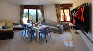 a living room with a table and a tv at B&B al Vittoriale da Maja in Gardone Riviera