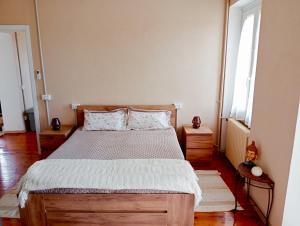 a bedroom with a wooden bed and a window at Residenza il Rododendro in Candelo