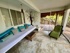 a living room with a couch and a chair at Casa Pauline Beach house habitaciones con acceso directo a playa y alberca in Arroyo Cruz