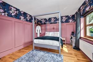 a bedroom with pink and blue walls and a bed at Carnbore House BnB in Bushmills