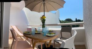 a table with a vase of flowers and an umbrella at Ô Ponant in La Grande-Motte +28 photos