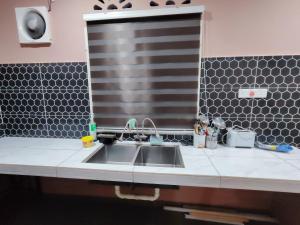 a kitchen counter with a sink and a mirror at Homestay Temerloh Free Netflix Wi-fi 300MBPS 4 Bedroom 3 Air-cond Water Heater Water Filter in Temerloh