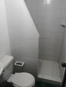 a white bathroom with a toilet and a sink at Hostal BioHotel Caribe Green in Santa Marta +18 photos