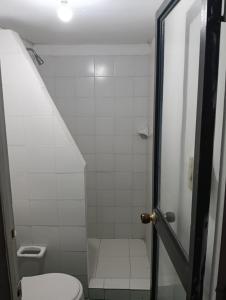 a small bathroom with a toilet and a shower at Hostal BioHotel Caribe Green in Santa Marta