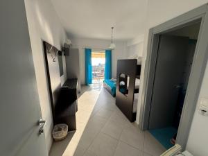 a room with a bathroom with a toilet and a hallway at Hotel Sunset in Dhërmi