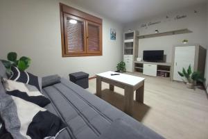 a living room with a couch and a table at Casa do Carpinteiro in Brocos
