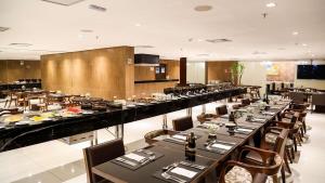 una grande sala da pranzo con tavoli e sedie lunghi di Flat Luxo no Hotel Radisson Belém a Belém