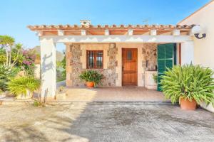 a house with a wooden door and potted plants at Villa Vinya Maria by Villa Plus in El Port