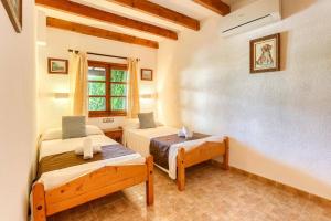 a bedroom with two beds and a window at Villa Vinya Maria by Villa Plus in El Port +20 photos