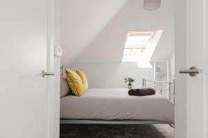 a bedroom with a bed with yellow pillows at The Nook, Fairview, Cheltenham Town Centre-Parking & Garden in Cheltenham