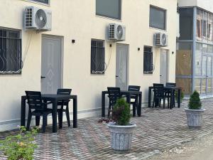 un grupo de mesas y sillas frente a un edificio en Apartamente me qera Golem, en Golem