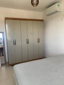 a bedroom with white cabinets and a bed at Cantinho da day in Aracaju +13 photos