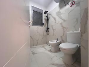 Un baño blanco con inodoro y lavabo. en Apartamente me qera Golem, en Golem 16 fotos más