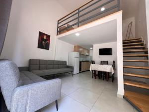 sala de estar con sofá, escalera y cocina en Apartamente me qera Golem, en Golem
