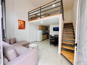 una sala de estar con una escalera que conduce a un loft en Apartamente me qera Golem, en Golem