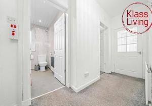 a bathroom with a toilet and a door with the words kiss living at Uddingston Apartment by Klass Living in Uddingston +19 photos