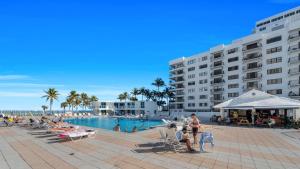 una piscina junto a un gran edificio de apartamentos en SeaStays ~ Oceanfront Apartments, en Miami Beach