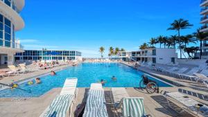 Una piscina en un resort con gente en ella. en SeaStays ~ Oceanfront Apartments, en Miami Beach