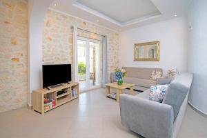 a living room with a couch and a television at Villa Danai by Villa Plus in Karyótikon