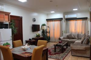 Una cocina y una sala de estar con una mesa y un sofá. en Apartments Hadaiq AL Khalij For Serviced Apartments شقق حدائق الخليج للشقق المخدومه, en Dammam