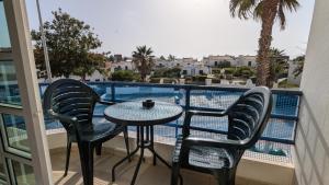 a balcony with a table and chairs and a pool at Apartamentos Sereia da Oura in Albufeira