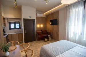 a bedroom with a bed and a table and a couch at ikosapartments square 1-2 in Perdika