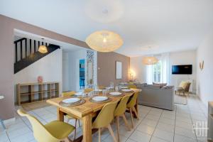 a dining room and living room with a table and chairs at Maison familiale proche hôpital Trousseau - Garage in Chambray-lès-Tours