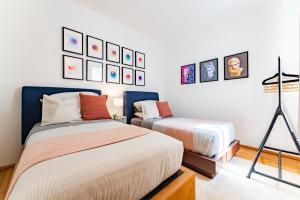 a bedroom with two beds and pictures on the wall at Bright and Secure Condo near Chapultepec & Museums in Mexico City