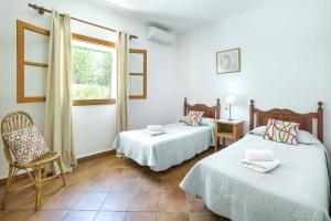 pokój z dwoma łóżkami, krzesłem i oknem w obiekcie Villa Monica by Villa Plus w mieście Cacla D'or