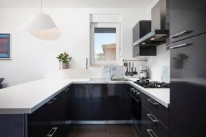 a kitchen with black and white cabinets and a window at Apartment with big open terrace in Pula