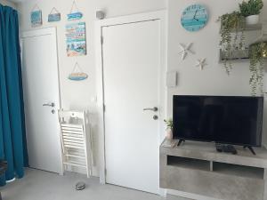 a living room with a flat screen tv on a wall at Blue Happy Place Middelkerke in Middelkerke