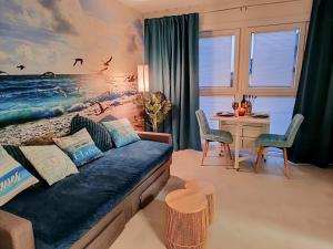 a living room with a couch and a table at Blue Happy Place Middelkerke in Middelkerke