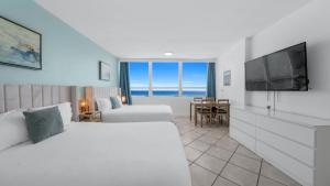 una habitación de hotel con una cama y un televisor en SeaStays ~ Oceanfront Apartments, en Miami Beach