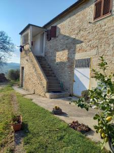 a brick building with a staircase leading to a garage at Countryhouse Gli Ulivi in Cossignano