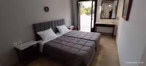 a bedroom with a bed and a sink and a mirror at ODYSSEAS HOTEL SAMOS in Samos
