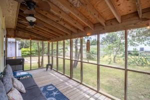 a screened in porch with a couch and some windows at Shell'd Inn in Kill Devil Hills