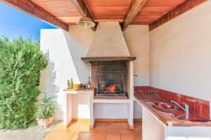 a outdoor kitchen with a fireplace on a patio at Villa Oliver by Villa Plus in El Port