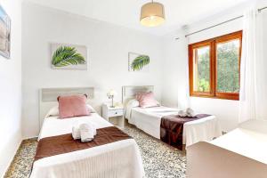 a bedroom with two beds and a window at Villa Oliver by Villa Plus in El Port +13 photos