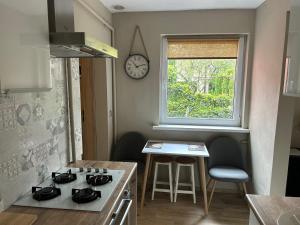 a kitchen with a stove and a clock on the wall at Apartament dwupokojowy z ogrodem in Poznań