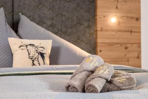 een persoon met sokken op een bed met een koeienkussen bij BEIM LOIS Edelweiss - AlpenLuxus Collection in Gerlos
