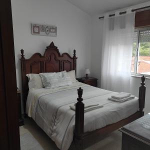 a bedroom with a large bed with a wooden headboard at Casa Furt@do in Burgau