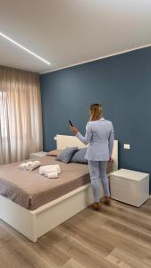a woman standing next to a bed in a bedroom at SUITE Rosso Conero - Le Grotte Rooms And Apartments in Camerano