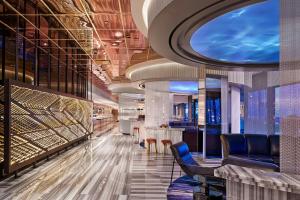 a lobby with a bar with blue chairs and tables at The Wade in Chicago